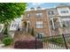 Brick townhome with a well-manicured lawn, iron fence, stairs and covered porch at 4196 Morrison Way # 11, Atlanta, GA 30341
