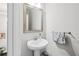 Stylish powder room featuring a pedestal sink, decorative mirror, and elegant fixtures at 4196 Morrison Way # 11, Atlanta, GA 30341