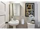Cozy powder room with a pedestal sink, mirror, and modern artwork at 812 Stratford Rd, Avondale Estates, GA 30002