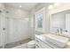 This bathroom has a glass shower door and a modern sink with white cabinetry, topped with a sleek white countertop at 812 Stratford Rd, Avondale Estates, GA 30002