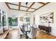 Charming dining room with a wood beam ceiling, modern chandelier, and large windows for natural light at 812 Stratford Rd, Avondale Estates, GA 30002