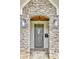 Charming stone entryway featuring an arched doorway, stylish lighting, and a welcoming front door at 812 Stratford Rd, Avondale Estates, GA 30002