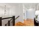 Bright hallway features hardwood floors, modern light fixtures, a black metal handrail, and fresh white walls at 812 Stratford Rd, Avondale Estates, GA 30002