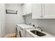 Bright laundry room with a utility sink, storage cabinets, and modern washer and dryer units at 812 Stratford Rd, Avondale Estates, GA 30002