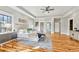Bright main bedroom featuring hardwood floors, tray ceilings, a ceiling fan, and views of the surrounding landscape at 812 Stratford Rd, Avondale Estates, GA 30002
