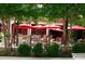 Outdoor patio of the LONA restaurant, featuring shaded dining with red umbrellas and greenery at 812 Stratford Rd, Avondale Estates, GA 30002