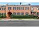 Classic brick townhome featuring an arched entry, manicured hedges, and American flag at 3456 Paces Nw Pl, Atlanta, GA 30327
