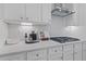 Kitchen features gas cooktop and herringbone backsplash at 189 Haverling Pass, Hampton, GA 30228