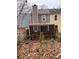 A weathered backyard deck with a grill, surrounded by trees and fallen leaves at 1799 Timber Valley Se Way, Smyrna, GA 30080