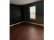 Bedroom featuring dark green walls, laminate wood flooring, and a window overlooking the greenery outside at 1799 Timber Valley Se Way, Smyrna, GA 30080