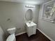 Clean bathroom with single vanity, oval mirror, and dark wood floor at 4208 Rue Saint Michel, Stone Mountain, GA 30083