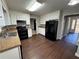 Galley kitchen with white cabinets, black appliances, and new flooring at 4208 Rue Saint Michel, Stone Mountain, GA 30083