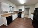 Kitchen with white cabinets, black appliances, and new flooring at 4208 Rue Saint Michel, Stone Mountain, GA 30083