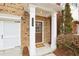 Close-up of the inviting front entrance with a classic brown door and white supporting pillars at 2159 Meadow Peak Rd, Duluth, GA 30097