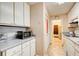 Galley kitchen with white cabinets, gray countertops, and microwave at 2515 Impala Dr, Cumming, GA 30041