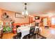 Open living and dining area with orange walls, wood floors, and a comfy couch at 2515 Impala Dr, Cumming, GA 30041