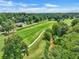 An aerial view of a winding golf course lined with beautiful trees and some houses at 564 Greystone Trce, Marietta, GA 30068