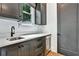 Wet bar with sink, wine cooler, dark gray cabinets, and light countertops, located next to a door at 564 Greystone Trce, Marietta, GA 30068