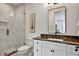 Bathroom with a marble countertop, white cabinetry, a toilet, and a walk-in shower with gray and white tiles at 564 Greystone Trce, Marietta, GA 30068