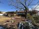 Ranch house back view with mature trees, bird bath, and winter grass at 457 Castleaire Dr, Stone Mountain, GA 30087