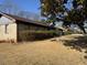 Brick ranch house with mature shrubs and winter grass at 457 Castleaire Dr, Stone Mountain, GA 30087