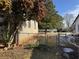 Side yard with chain link fence, needs landscaping, and small gate at 457 Castleaire Dr, Stone Mountain, GA 30087