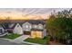 Two-story home with white brick and a landscaped yard at sunset at 9165 Golfview Ln, Covington, GA 30014