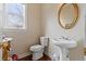 Charming powder room featuring a pedestal sink, decorative mirror, and hardwood floors at 3130 Caney Creek Ln, Cumming, GA 30041