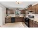 Galley kitchen with wood cabinets, tile flooring and black appliances at 730 Lake Forest Pass, Roswell, GA 30076