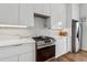 Modern white kitchen featuring stainless steel appliances, quartz counters, and hardwood floors at 75 Boulevard Ne # 1, Atlanta, GA 30312