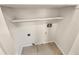 A dedicated laundry area with tile flooring, convenient hookups, and a shelf for storage at 2781 Interlaken Dr, Marietta, GA 30062