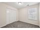 Bright bedroom with carpet flooring, window with blinds, and built-in closet at 1025 Rock Creek Ln, Norcross, GA 30093