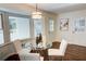 Bright dining area with glass table and white chairs, hardwood floors, and large windows at 1080 Willow Bnd, Roswell, GA 30075