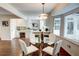 Bright dining area with glass table and white chairs, hardwood floors, and view of kitchen at 1080 Willow Bnd, Roswell, GA 30075