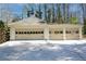 Three-car garage with light beige doors and a spacious driveway at 1080 Willow Bnd, Roswell, GA 30075