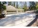 Three-car garage with light beige doors and a large driveway at 1080 Willow Bnd, Roswell, GA 30075