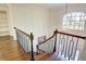 Dark wood staircase with metal railing and arched window above at 1080 Willow Bnd, Roswell, GA 30075