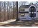 Two-story house nestled in a wooded area, featuring a white exterior and black accents at 205 Hardman Way, Woodstock, GA 30188