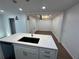 Kitchen island with white countertop, modern sink, pendant lights and view into living room at 205 Hardman Way, Woodstock, GA 30188