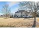 Wide shot of backyard with multiple windows along back of home, tall trees, and a fenced in lawn at 2602 Alcovy Club Dr, Dacula, GA 30019