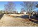 Fenced backyard view with an open lawn area and mature trees with clear blue skies in the background at 2602 Alcovy Club Dr, Dacula, GA 30019