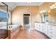 Bright bathroom with a large tub, dual granite vanities, tile floors and neutral color palette at 2602 Alcovy Club Dr, Dacula, GA 30019