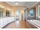 This bathroom features a large bathtub, glass enclosed shower, and dual sink granite vanity at 2602 Alcovy Club Dr, Dacula, GA 30019