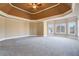 Large carpeted main bedroom with decorative tray ceiling and multiple windows for natural light at 2602 Alcovy Club Dr, Dacula, GA 30019