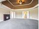 Expansive carpeted main bedroom with a decorative tray ceiling and fireplace at 2602 Alcovy Club Dr, Dacula, GA 30019