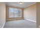 This is a carpeted bedroom with neutral walls, bright windows with blinds, and overhead lighting at 2602 Alcovy Club Dr, Dacula, GA 30019