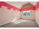 Bright bedroom featuring unique wall decor, carpet, and a large window with natural light at 2602 Alcovy Club Dr, Dacula, GA 30019