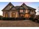 Stunning brick home illuminated at dusk, highlighting architectural details and inviting curb appeal at 2602 Alcovy Club Dr, Dacula, GA 30019