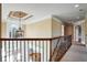 Hallway with detailed ceiling, decorative lighting, and black metal railing at 2602 Alcovy Club Dr, Dacula, GA 30019