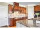 Close-up of kitchen details showcasing granite countertops, stainless steel appliances and a custom range hood at 2602 Alcovy Club Dr, Dacula, GA 30019